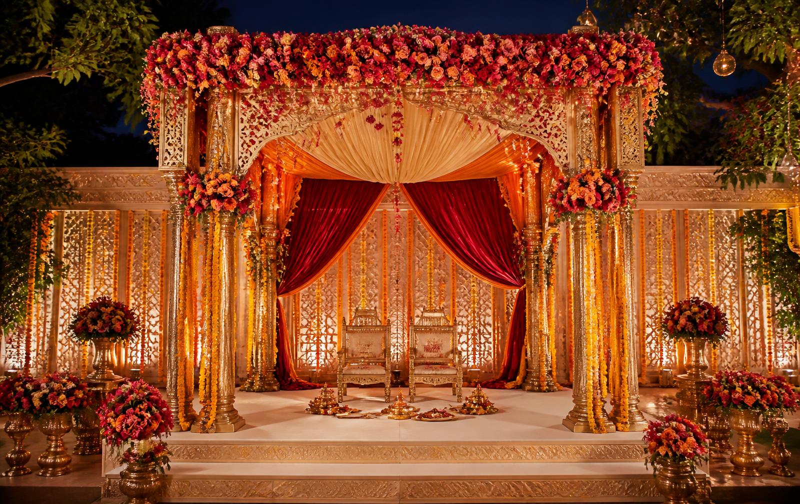 Couple beneath a floral wedding mandap at golden hour